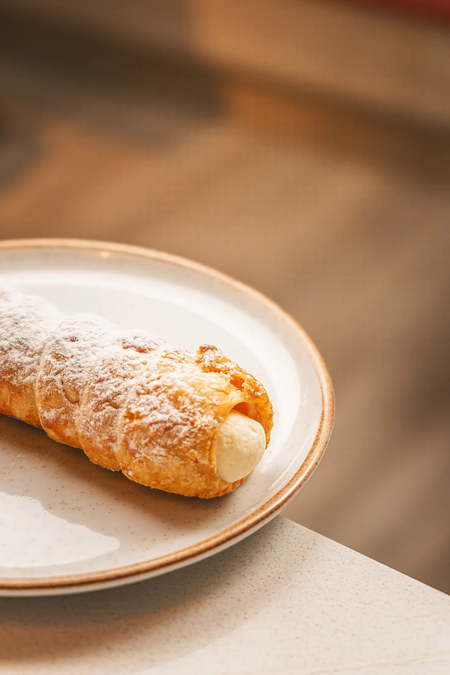 canuto relleno de crema espolvoreado con azúcar en Pastelería Saint Michel